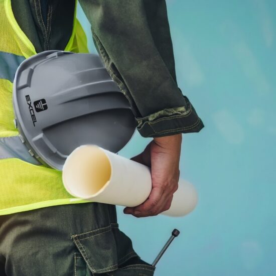 Excel Electric Contractor working at Downers Grove, holding a hard hat and a scroll of paper